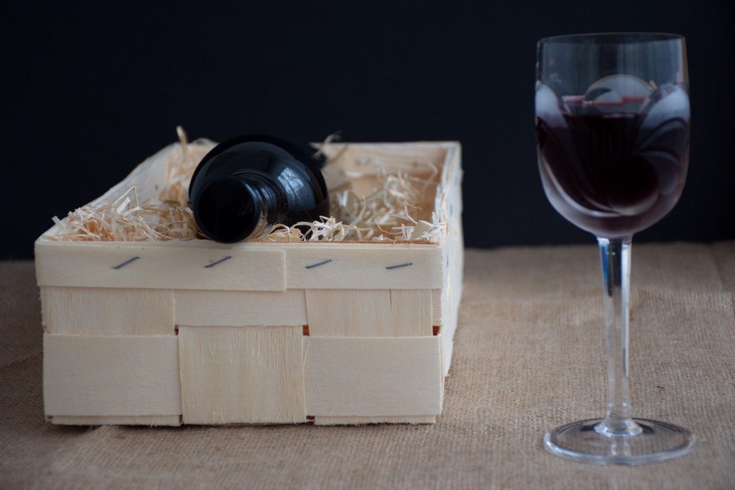 nominated-already-bottle-of-wine-in-wooden-box-with-straw-crystal-wine-glass-with-red-wine_t20_P1ZBAR